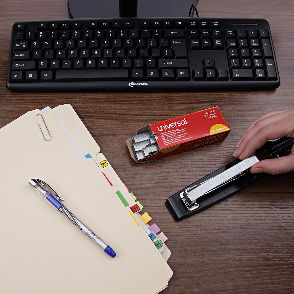 Close up of desk top with person refilling stapler with universal staples